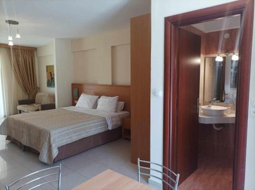 Alex House في زاخارو: غرفة الفندق بسرير ومغسلة