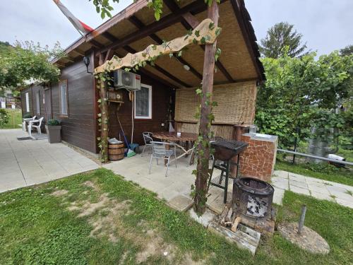 a patio with a table and a grill in a yard at Dedin Konak in Golubac