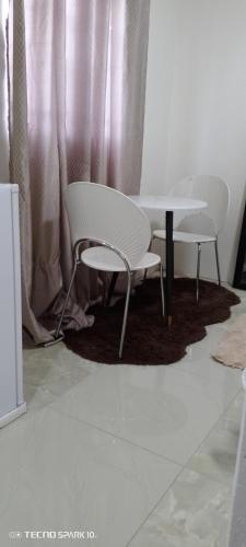 dwa białe krzesła i stół w pokoju w obiekcie Sunset Shades w mieście Francistown