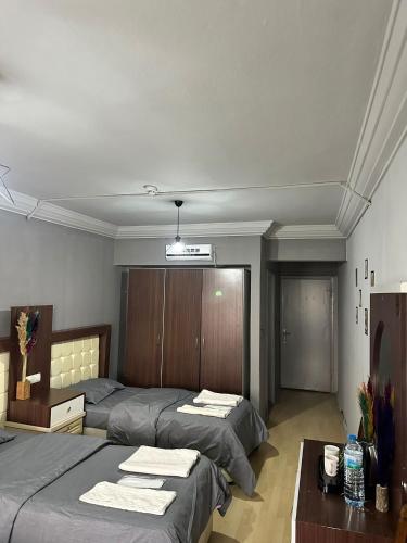 a bedroom with two beds and a desk and a table at NIGRUM HOTEL in Nevsehir