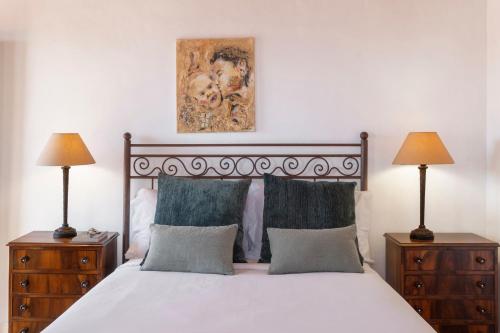 a bedroom with a bed with two night stands and two lamps at Quinta da Fonte by An Island Apart in Calheta