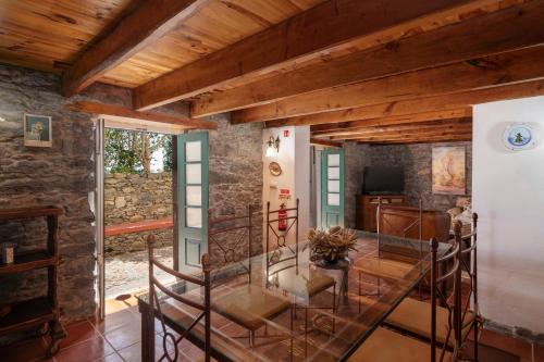 a room with wooden ceilings and a glass table at Quinta da Fonte by An Island Apart in Calheta