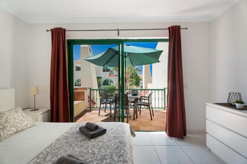 een slaapkamer met een balkon met een tafel en een parasol bij Mareverde K131 in Adeje