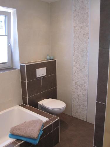 a bathroom with a toilet and a bath tub at Ferienwohnung Bergpanorama in Fulpmes