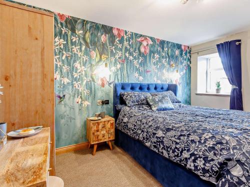 a bedroom with a blue bed with a floral wallpaper at 3 Bed in Lanark 81079 in Forth