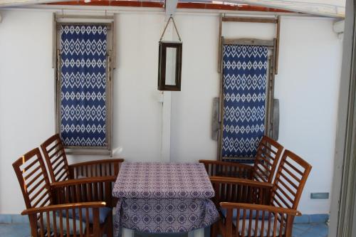 a table with four chairs and a table with a table cloth at la mansarda sul Porto in Ponza