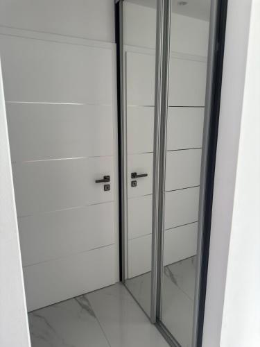 a glass door in a room with white cabinets at Belle Casa Villa in Debrecen