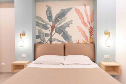 a bedroom with a bed with a painting on the wall at Antares Rooms and Suites in Olbia