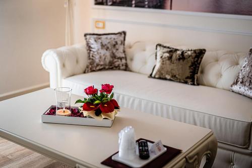 a living room with a couch and a table with flowers at Hotel Ca' D'Oro Tre Stelle Superior Adults only in Bibione