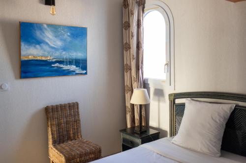 une chambre avec un lit, une chaise et une fenêtre dans l'établissement Très bel appartement 4 pièces en duplex face Marinas, à Saint-Cyprien