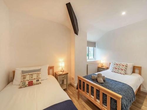 two beds in a small room with two lamps at 4 Bed in Keswick 86248 in Rosthwaite
