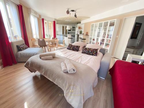 een slaapkamer met een groot bed en handdoeken bij Noisy-le-roi Cœur-Village in Noisy-le-Roi