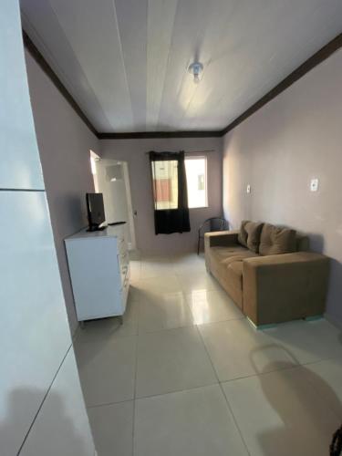ein Wohnzimmer mit einem Sofa und einem TV in der Unterkunft Hoje Apartamentos in Feira de Santana