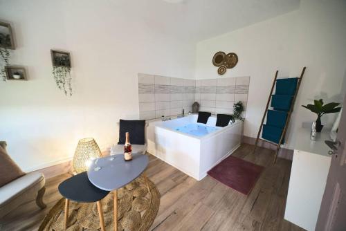- un salon avec une baignoire, une table et des chaises dans l'établissement Pacat Insolite Jacuzzi ParkingFree Centre à 5min, à Mulhouse