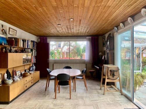 uma sala de jantar com uma mesa e cadeiras e uma janela em Maison familiale avec jardin proche Rouen centre et Armada em Sotteville-lès-Rouen