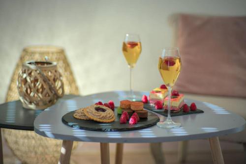 - une table avec deux verres de vin et une assiette de nourriture dans l'établissement Pacat Insolite Jacuzzi ParkingFree Centre à 5min, à Mulhouse