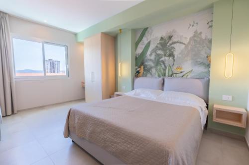 a bedroom with a large bed and a painting on the wall at Antares Rooms and Suites in Olbia