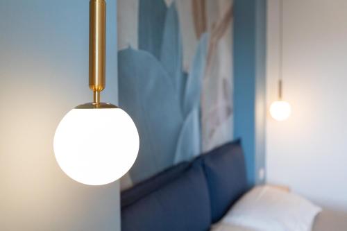 a light hanging from a wall next to a couch at Antares Rooms and Suites in Olbia