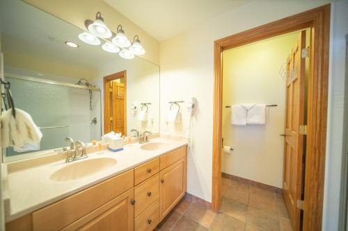 un bagno con due lavandini e un grande specchio di Hidden River Lodge 5979 a Keystone