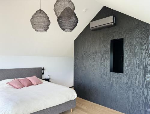 a bedroom with a bed and two pendant lights at Durbuy Insolite - Natural Escape in Durbuy