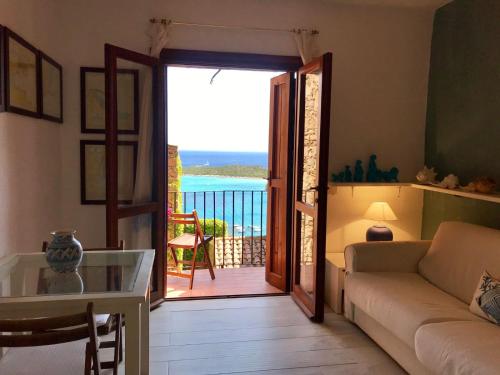 a living room with a couch and a view of the ocean at Villaggio Est a Capo Coda Cavallo San Teodoro in San Teodoro