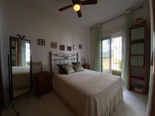 a bedroom with a bed and a ceiling fan at Apartamento a pie de playa in Rota