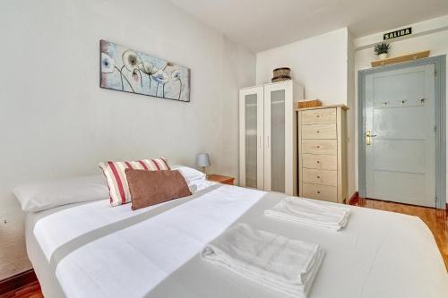 パンプローナにあるMesón Pamplona by Clabaoのベッドルーム(大きな白いベッド1台、ドレッサー付)