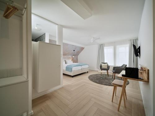 1 dormitorio con 1 cama y 1 habitación con escritorio en Hotel Siebzehn80, en Carolinensiel