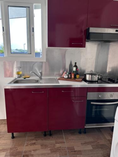 a kitchen with purple cabinets and a sink at A MO TI KOTE in Guenouillet