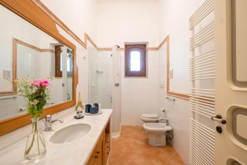 La salle de bains est pourvue d'un lavabo, de toilettes et d'un miroir. dans l'établissement Il Carretto, à Monteroni di Lecce