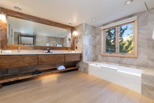 La salle de bains est pourvue d'une baignoire, d'un lavabo et d'un miroir. dans l'établissement The Peaks Resort and Spa, à Telluride