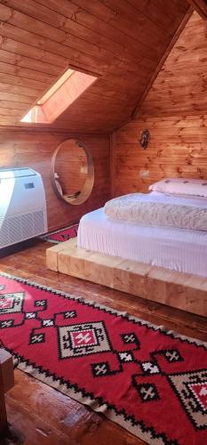 - une chambre avec un lit et un tapis au sol dans l'établissement Silver Hill Guesthouse, à Gjirokastër