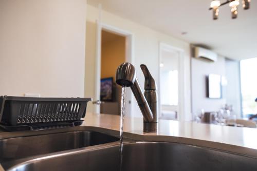a kitchen sink with water coming out of a faucet at Oceanview Apt Near Panama City w/ King Bed & More in Playa Bonita Village