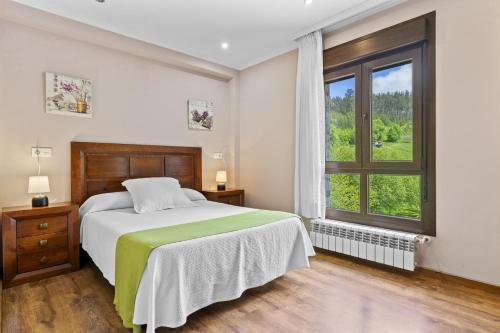ein Schlafzimmer mit einem Bett und einem großen Fenster in der Unterkunft Las Pilas in Soto del Barco