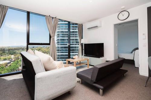 a living room with a couch a chair and a tv at Modern 2b2b Apt -2 king bed-2 parking-UC-Westfield in Belconnen