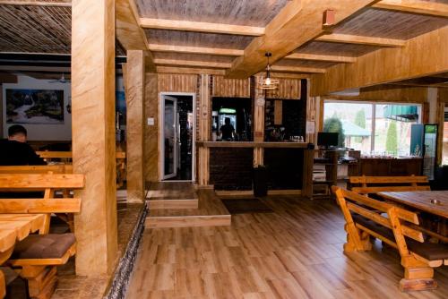 un ristorante con pavimenti in legno, tavoli e panche in legno di Etno selo Bok a Vrhpolje