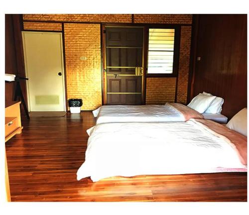 - duże białe łóżko w pokoju z drewnianą podłogą w obiekcie Dirt Venture 2 Day 1 Night Trips w mieście Chiang Mai