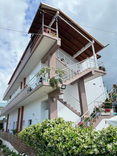 a white building with a balcony and stairs at Anel Studios in Vlorë