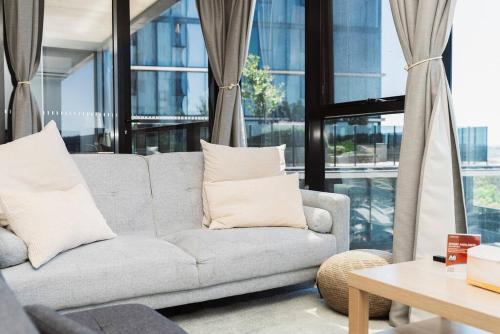 sala de estar con sofá y mesa en Modern 2b2b Apt -2 king bed-2 parking-UC-Westfield en Belconnen