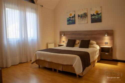 a bedroom with a large bed and a window at Departamentos - Belgrano 810 in San Martín de los Andes