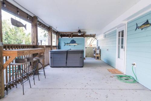 a back porch of a house with a fish on the wall at Somewhere On A Beach - Dog Friendly • Private Pool • Hot Tub • Fire Pit • Game Room • Horseshoe Pits • Walk to beach, Sound, arcade and go carts! in Kill Devil Hills