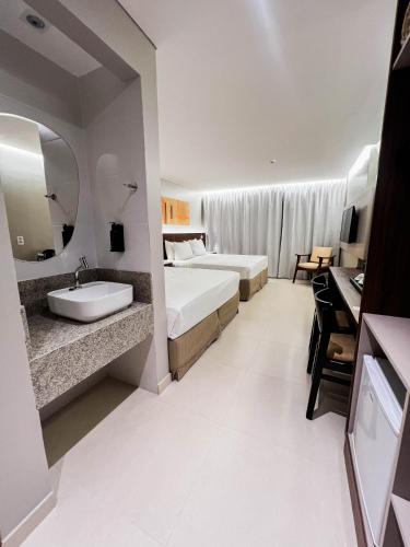 a hotel room with a bed and a sink at Smart Hotel João Pessoa in João Pessoa