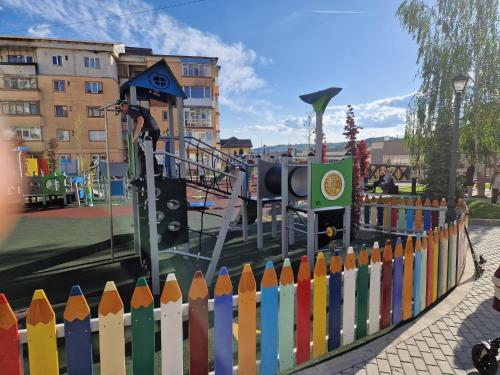 a playground with a colorful fence and a slide at Apartament 2 camere Campulung Muscel in Câmpulung