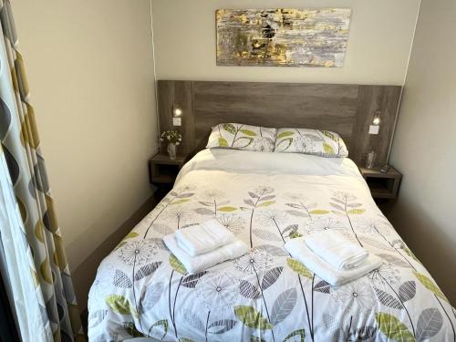 ein Schlafzimmer mit einem Bett mit zwei Handtüchern darauf in der Unterkunft Rowan Boutique Lodge for couples with a dog in York