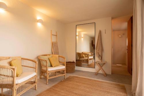 ein Wohnzimmer mit Korbstühlen und einem Spiegel in der Unterkunft Boutique Hotel Jardines de Palerm in San Jose