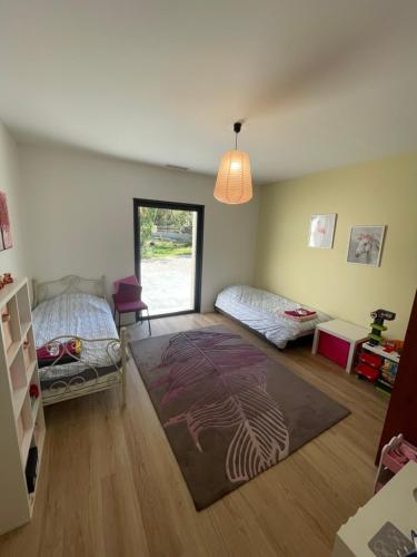 ein Zimmer mit zwei Betten und einem Teppich auf dem Boden in der Unterkunft Chambres d hôtes Maison des Romarins in Montferrier-sur-Lez