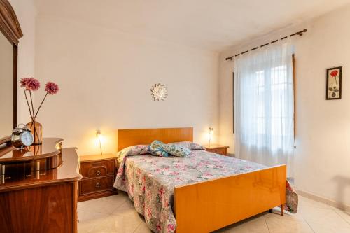 Schlafzimmer mit einem Bett, einem Tisch und einem Fenster in der Unterkunft Casa delle Rose in Borgo a Mozzano