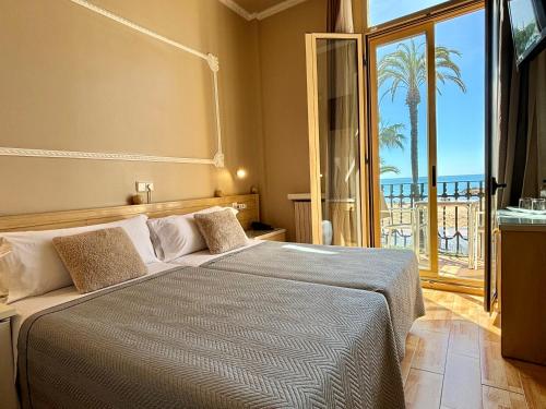 sypialnia z łóżkiem i widokiem na ocean w obiekcie Hotel Celimar w mieście Sitges