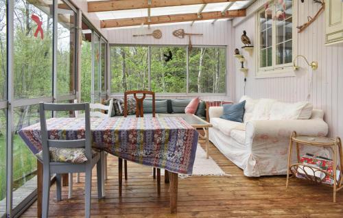a screened in porch with a table and a couch at Lovely Home In Kallinge in Kallinge
