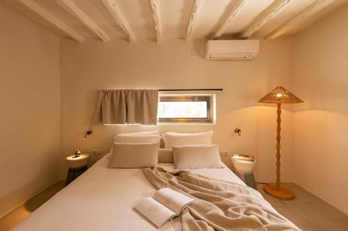 una camera da letto con un grande letto bianco con cuscini di Boutique Hotel Jardines de Palerm a San José